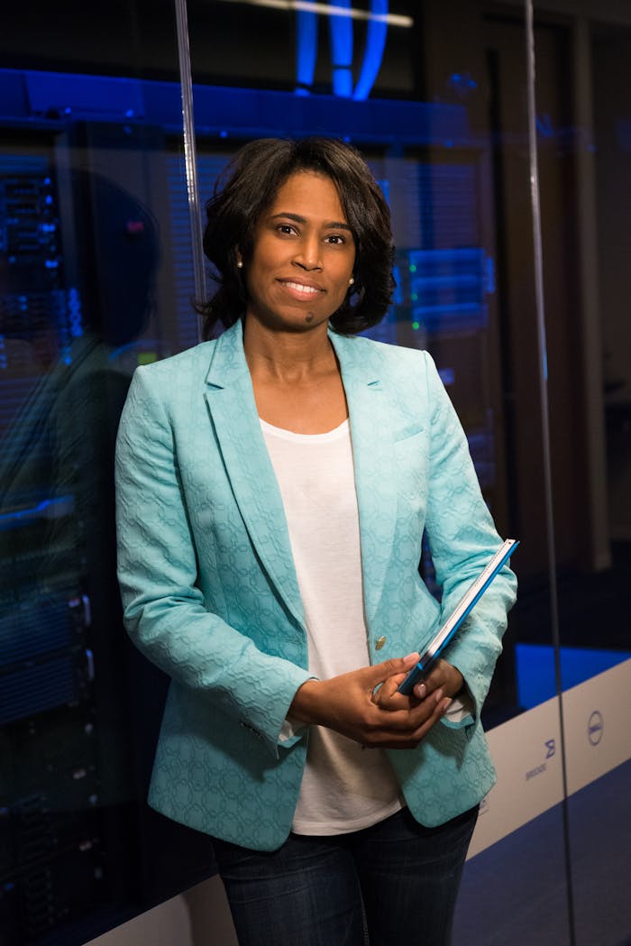 about-us Confident woman in a server room, holding a tablet. Ideal for tech and business themes.